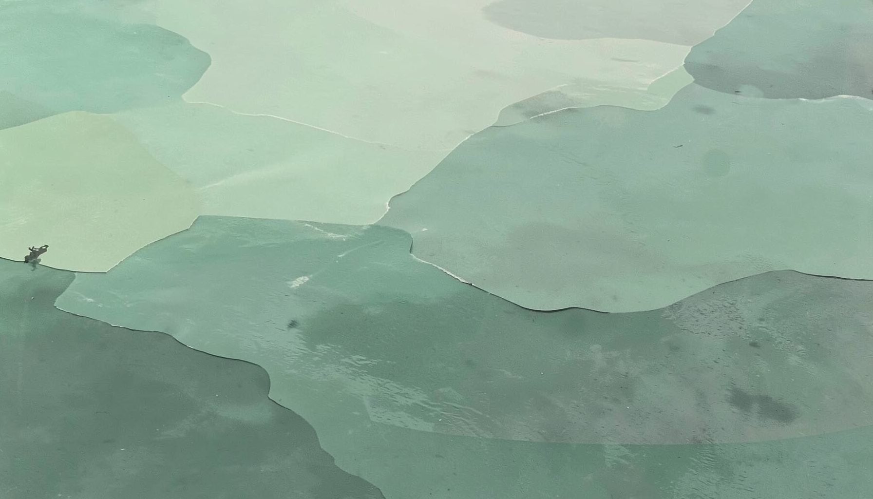 Coastal-inspired abstract graphic in muted greens and greys, evoking the Channel Islands